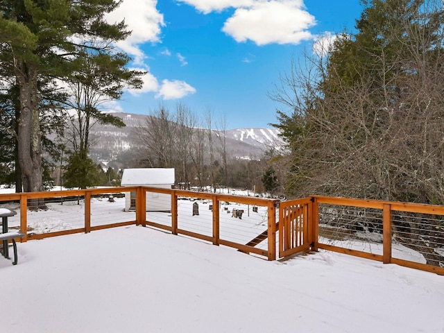 snow covered deck with a mountain view