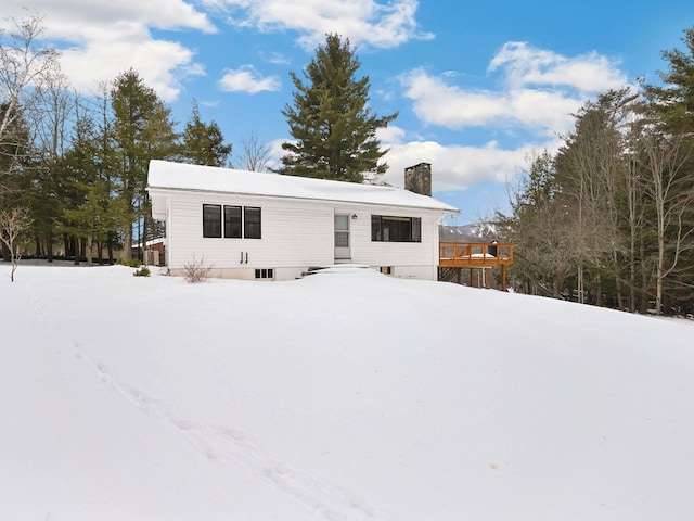 snow covered rear of property featuring a deck