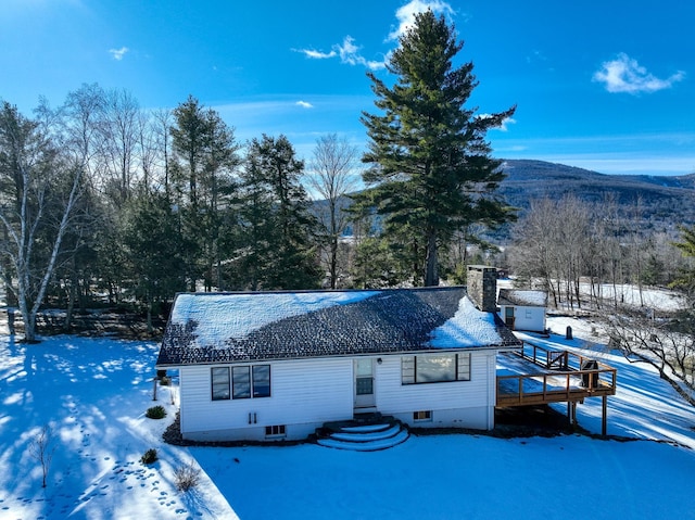 snow covered house featuring a mountain view