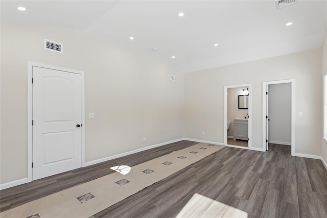 spare room featuring dark hardwood / wood-style flooring and vaulted ceiling