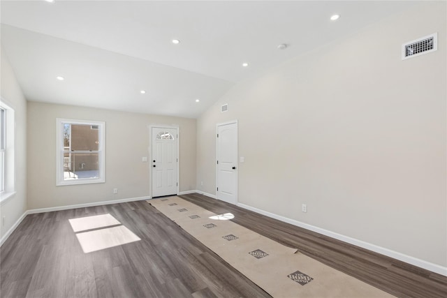 spare room with lofted ceiling and dark hardwood / wood-style flooring