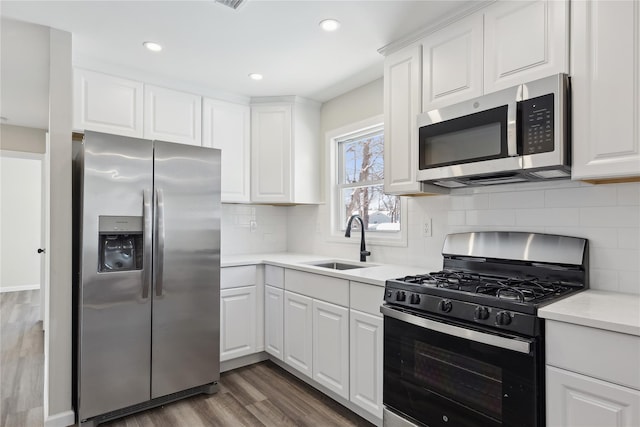 kitchen with white cabinetry, appliances with stainless steel finishes, dark wood-type flooring, and sink