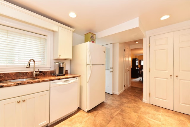 kitchen featuring white cabinetry, sink, white appliances, and dark stone counters