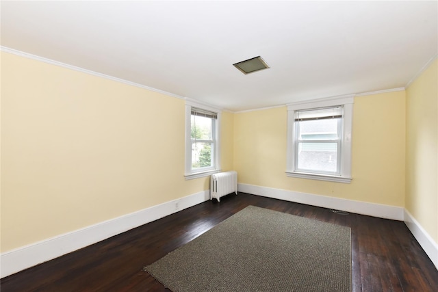 unfurnished room with crown molding, radiator heating unit, and dark hardwood / wood-style floors