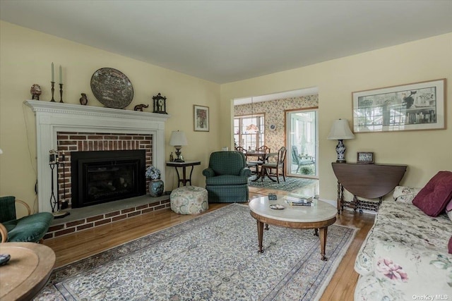 living room featuring a brick fireplace and wood-type flooring