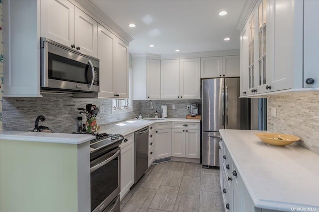 kitchen featuring white cabinetry, stainless steel appliances, sink, and tasteful backsplash