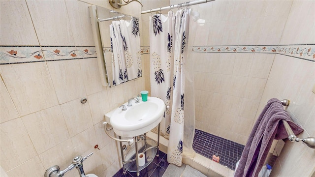 bathroom with tile walls, sink, and curtained shower