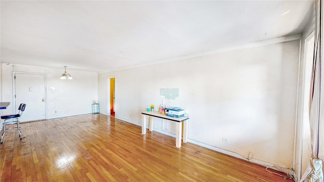 unfurnished room with a notable chandelier and hardwood / wood-style flooring