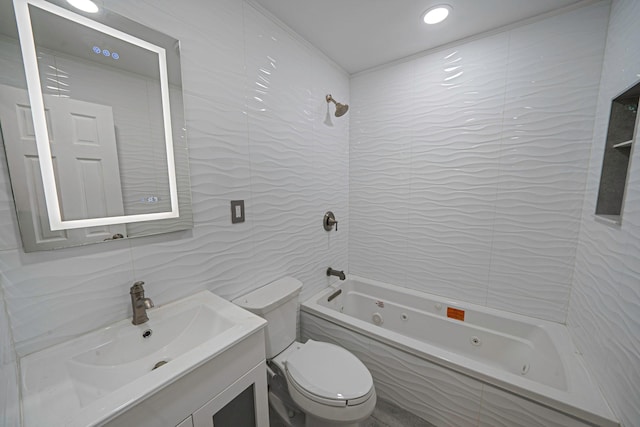 full bathroom featuring vanity, toilet, tiled shower / bath combo, and tile walls