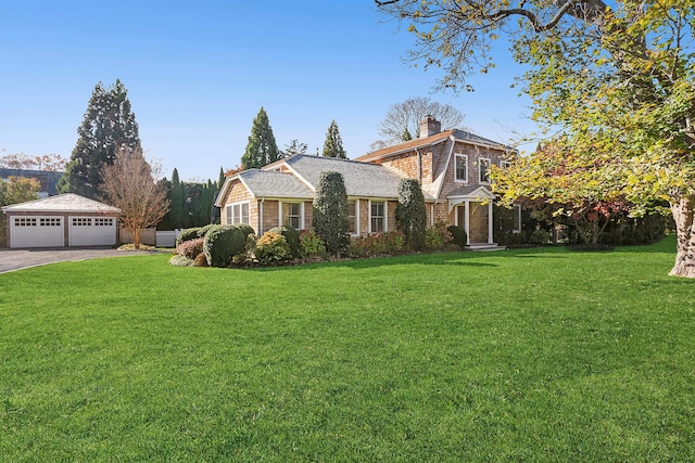 view of front of property with an outbuilding, a garage, and a front lawn