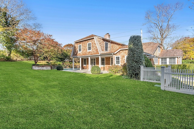 back of property featuring a patio and a yard