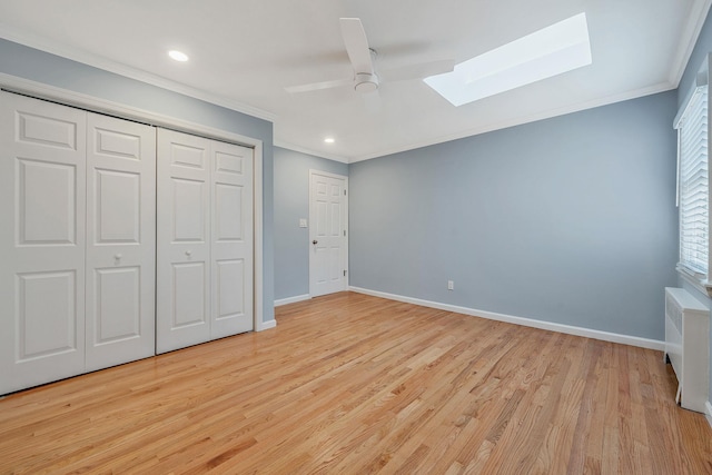 unfurnished bedroom with ornamental molding, light hardwood / wood-style floors, and a skylight