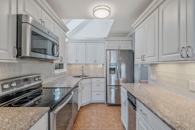 kitchen featuring light tile patterned flooring, sink, stainless steel appliances, decorative backsplash, and white cabinets