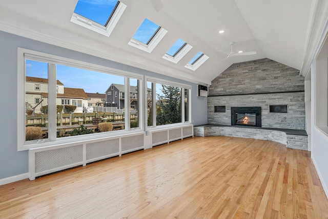 unfurnished living room with a fireplace, light hardwood / wood-style floors, and vaulted ceiling