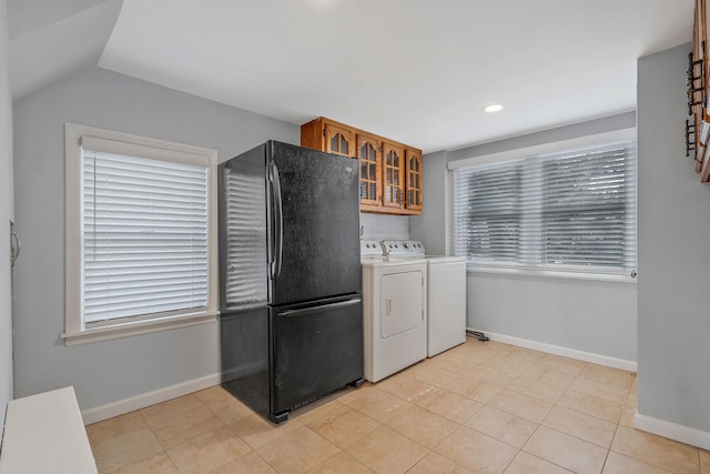 laundry room with cabinets, washer and dryer, and light tile patterned flooring