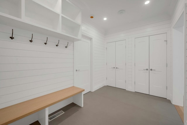 mudroom with wood walls