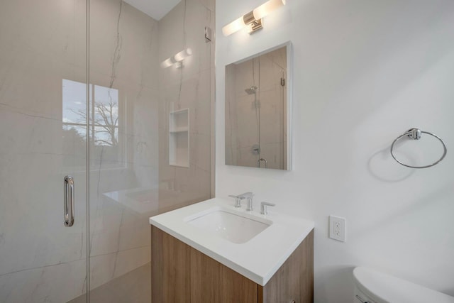 bathroom with vanity, toilet, and a shower with shower door