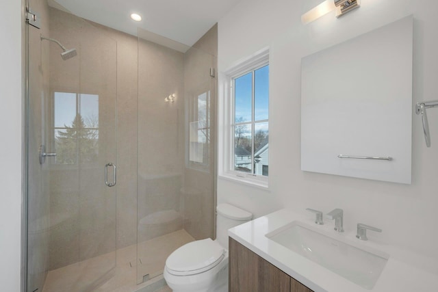 bathroom featuring vanity, toilet, and walk in shower