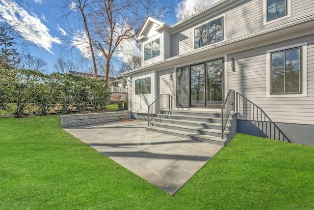 back of house featuring a patio area and a lawn