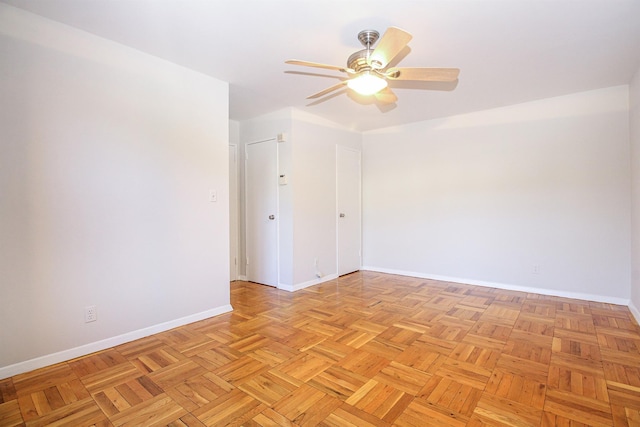 unfurnished room with ceiling fan and light parquet flooring