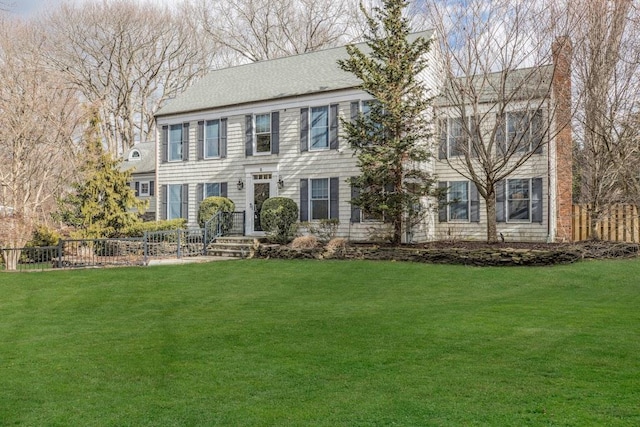 colonial house featuring a front lawn