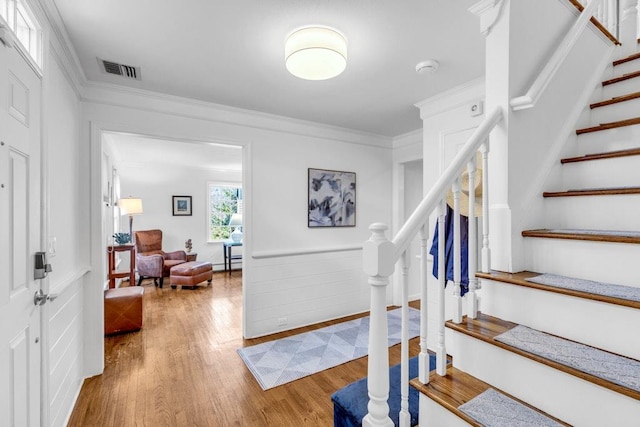 stairs featuring crown molding, hardwood / wood-style floors, and a baseboard radiator