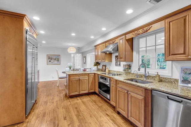 kitchen with sink, stainless steel appliances, light hardwood / wood-style floors, kitchen peninsula, and exhaust hood