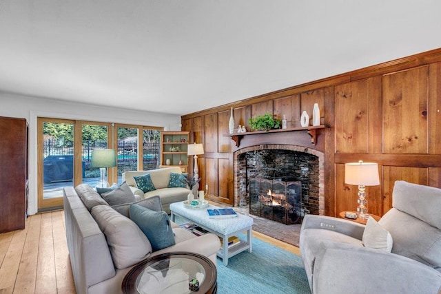 living room featuring a brick fireplace and light hardwood / wood-style flooring