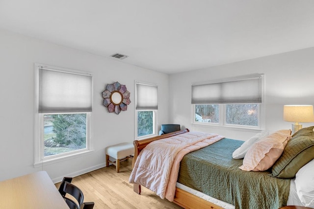 bedroom featuring multiple windows and light hardwood / wood-style floors