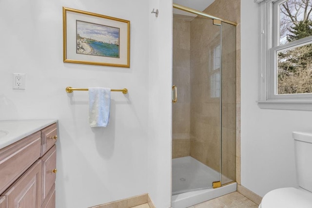 bathroom featuring vanity, a shower with door, and toilet