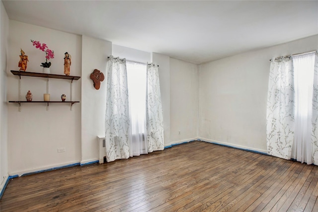 unfurnished room with dark wood-type flooring