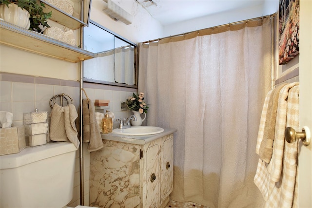 bathroom with tile walls, vanity, curtained shower, and toilet