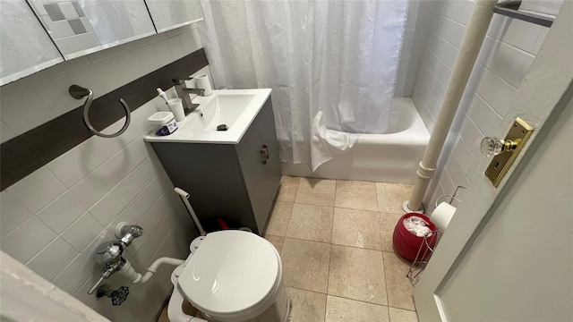 full bathroom with shower / bath combo, tile walls, vanity, tile patterned floors, and toilet