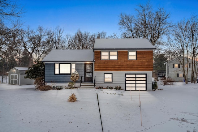 view of front of home with a garage and a shed