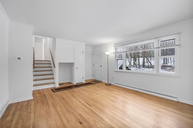 unfurnished living room featuring a baseboard heating unit, wood-type flooring, and ornamental molding