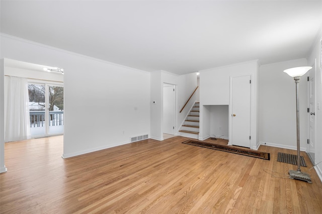 unfurnished living room featuring ornamental molding and light hardwood / wood-style floors