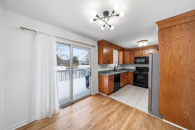 kitchen with sink, crown molding, a chandelier, light hardwood / wood-style floors, and black appliances