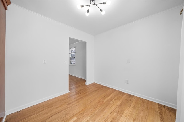 empty room with an inviting chandelier, ornamental molding, and light wood-type flooring