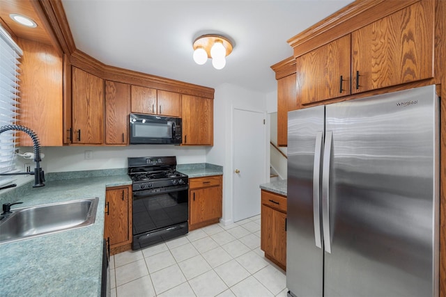 kitchen featuring sink, light tile patterned floors, and black appliances