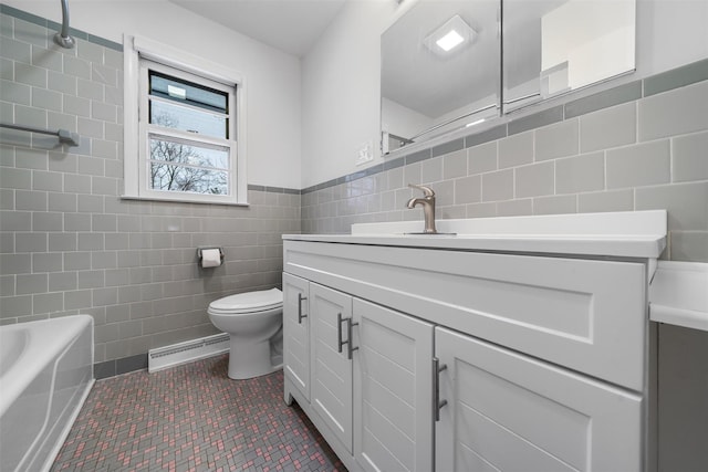 bathroom with toilet, tile walls, vanity, tile patterned flooring, and a baseboard heating unit