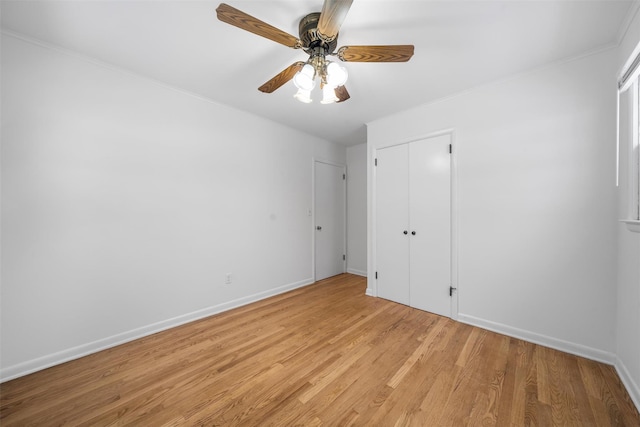 unfurnished bedroom featuring ceiling fan, ornamental molding, light hardwood / wood-style floors, and a closet