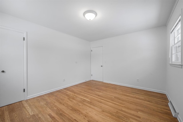 empty room featuring crown molding and light hardwood / wood-style floors