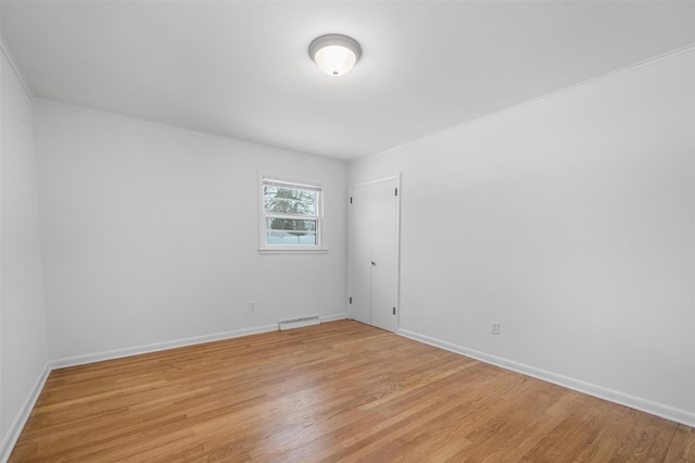 unfurnished room featuring ornamental molding and light hardwood / wood-style flooring