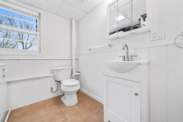 bathroom with vanity, a paneled ceiling, tile patterned floors, and toilet