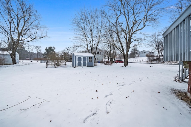 yard layered in snow with a storage unit