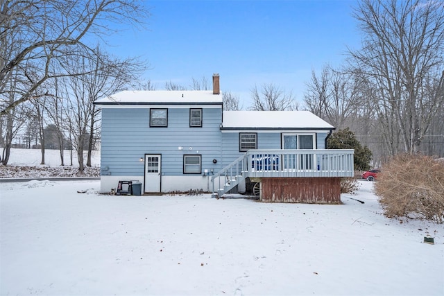 snow covered house featuring a deck