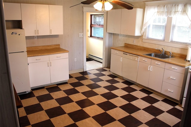 kitchen with sink, white appliances, a baseboard radiator, ceiling fan, and white cabinets