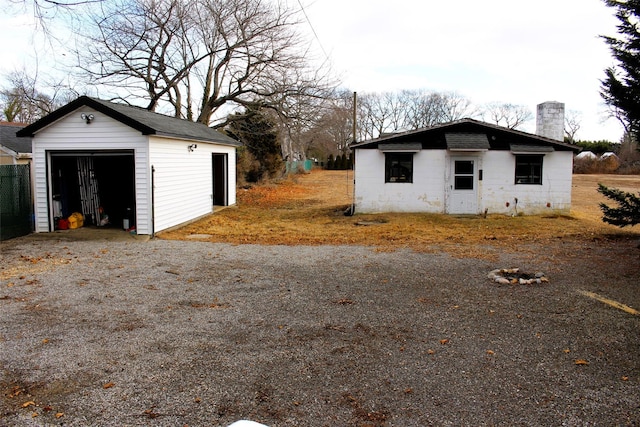 exterior space featuring a garage and an outbuilding