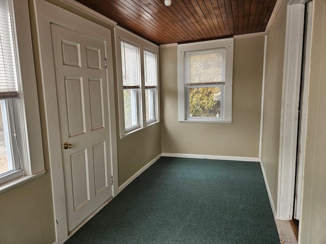 carpeted spare room with ornamental molding and wooden ceiling