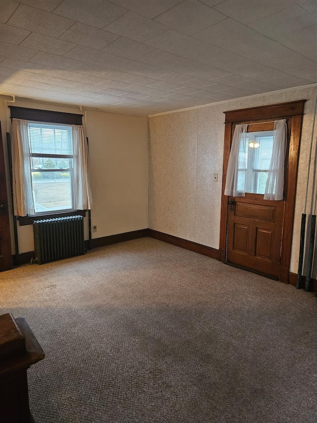 unfurnished room with radiator and carpet floors